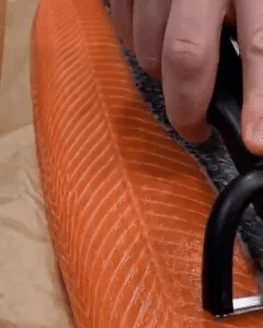 Handheld trimming tool being used on salmon